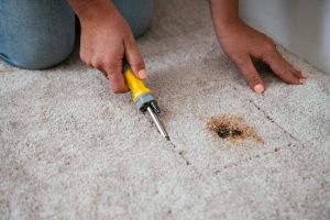 man repair carpet with his tool