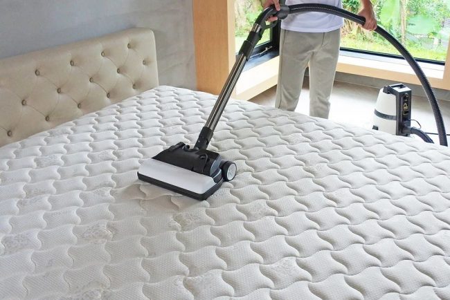 man try white mattress cleaning with his tool